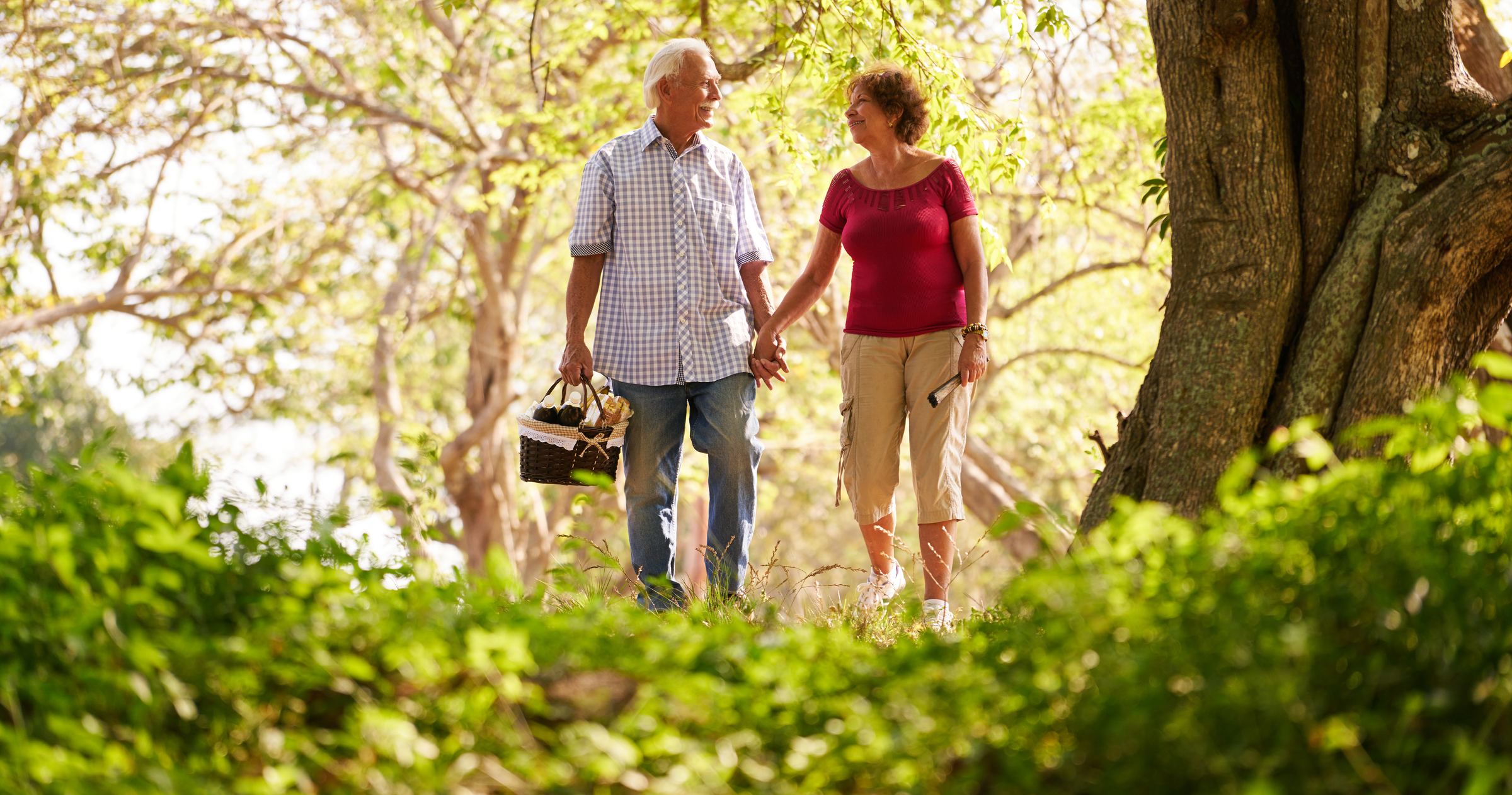 A man and a woman walking together on a sunlit path